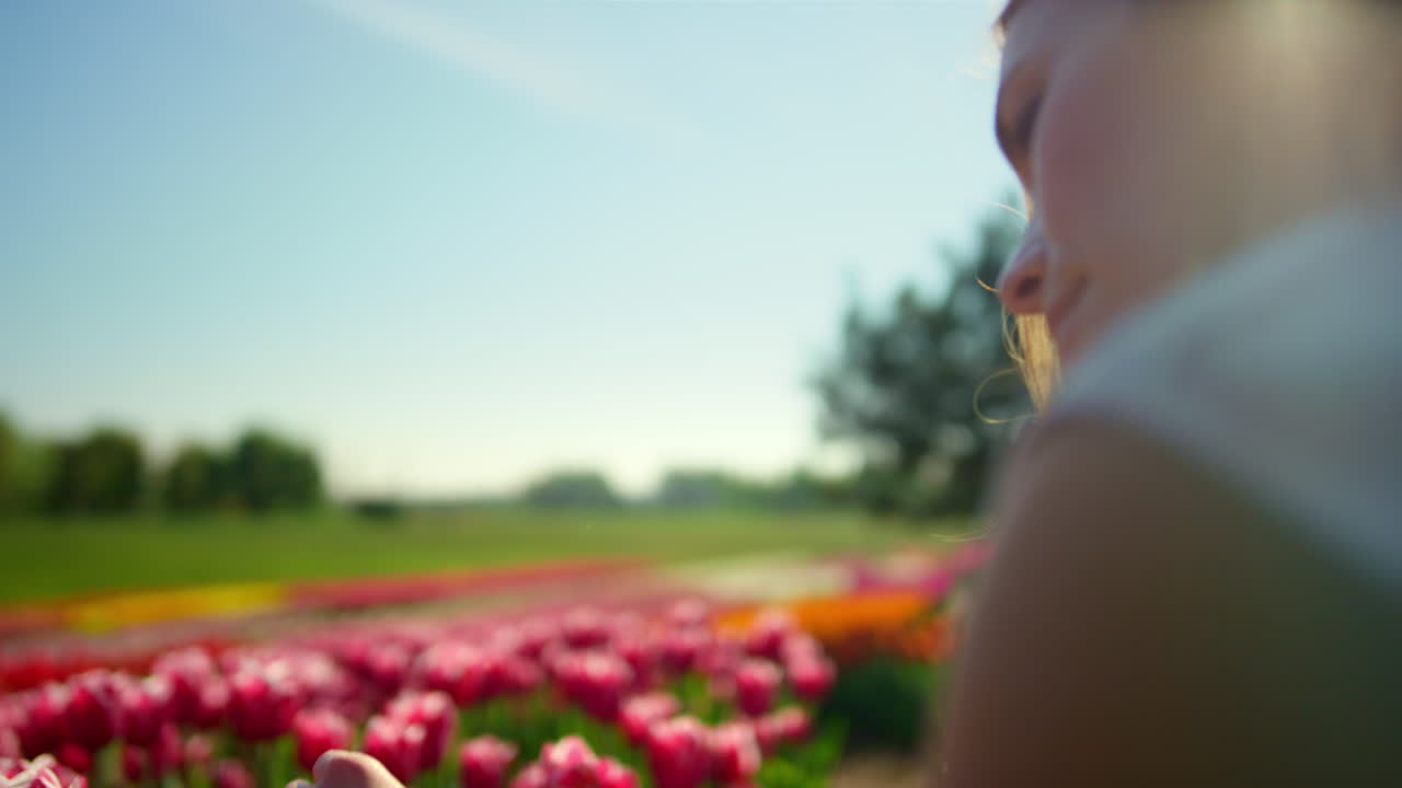 jardín de flores y chica soñadora al atardecer. mujer joven sentada en el campo de tulipanes.