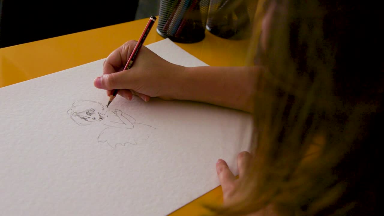 Close-up of a person drawing a cartoon sketch with a pencil