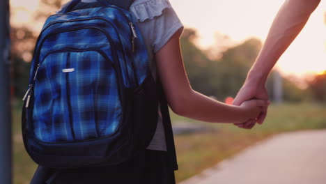 a young man leads his daughter by the hand to school