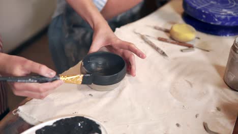 mujer pintando un cuenco de cerámica