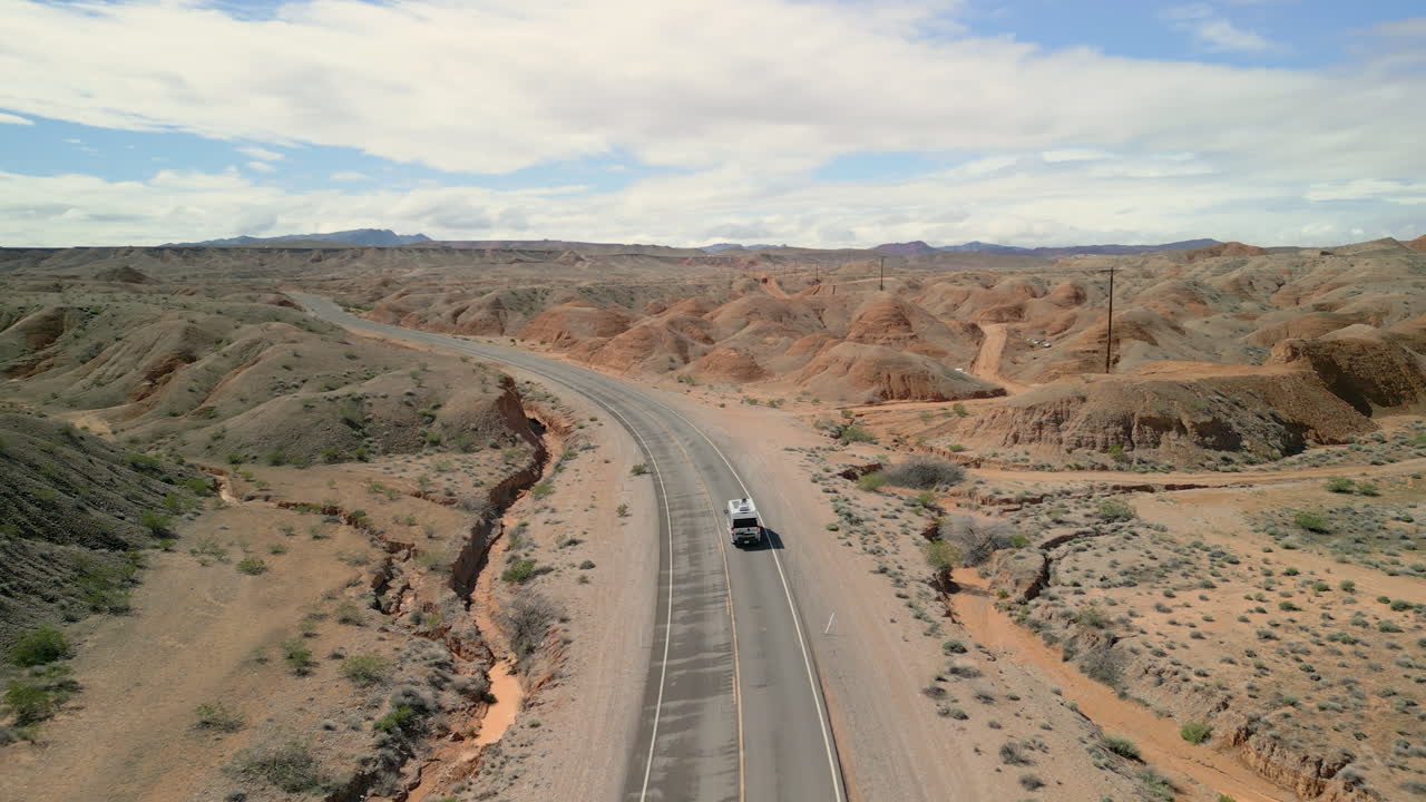 seguimiento disparado siguiendo como un rv conduce a lo largo de un camino tranquilo en el desierto