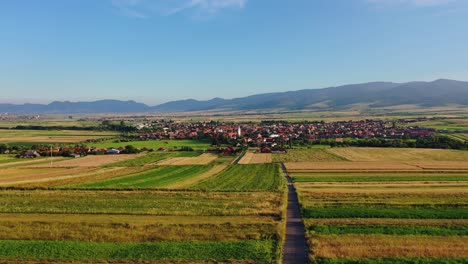 flying towards sancraieni, idyllic european village among farmland, romania