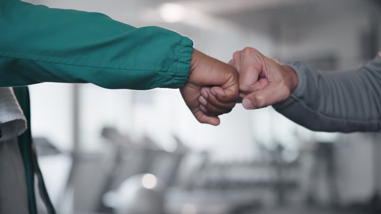 Fist bump between diverse individuals in a gym setting