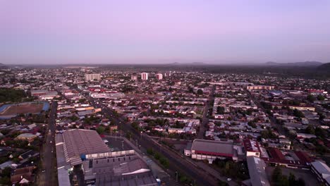 Aerial-view-establishing-the-city-of-Temuco-in-blue-hour,-under-rush-hour-city-traffic