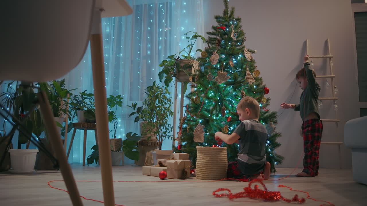 cámara de zoom: dos niños decorando un árbol de navidad en la víspera de navidad con árboles de navidad. imágenes de alta calidad 4k