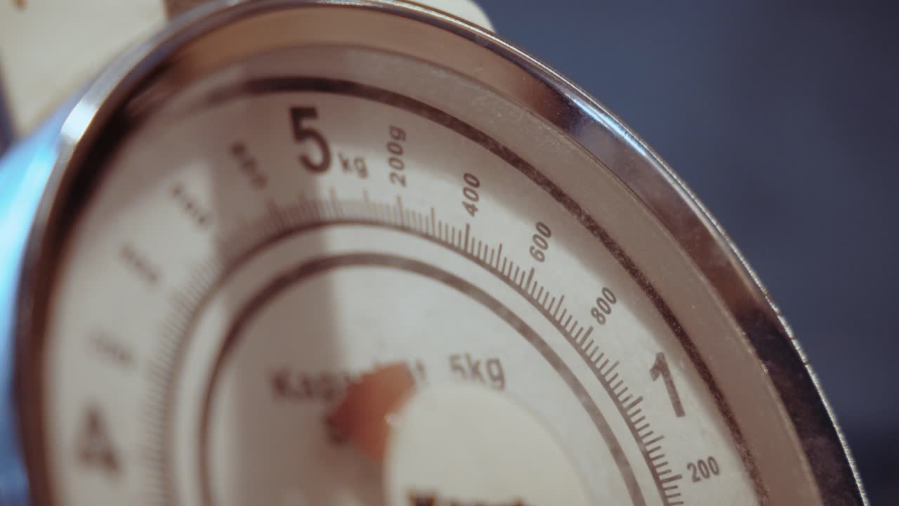 Ustencile of food-weighing scale moves across the dial, a symbol for health control