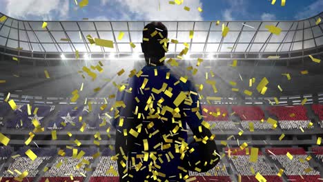 golden confetti over rear view of male rugby player holding rugby ball against sports stadium