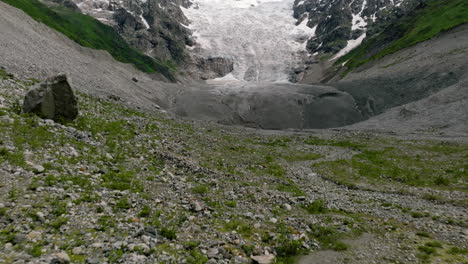 Volando-Sobre-Una-Montaña-Rocosa-Hasta-La-Lengua-Del-Glaciar-Adishi-Durante-El-Día-En-Svaneti,-Georgia