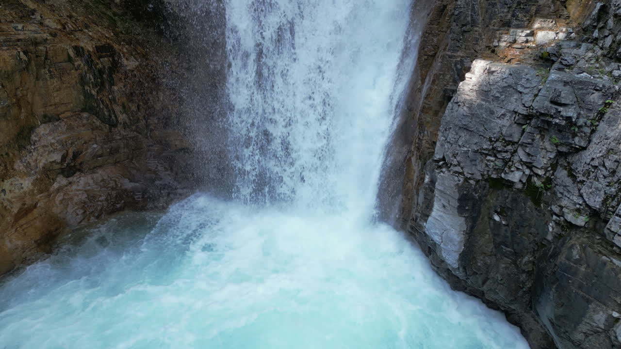 Felsiger Wasserfall fließt in blaues, sprudelndes Wasserbecken