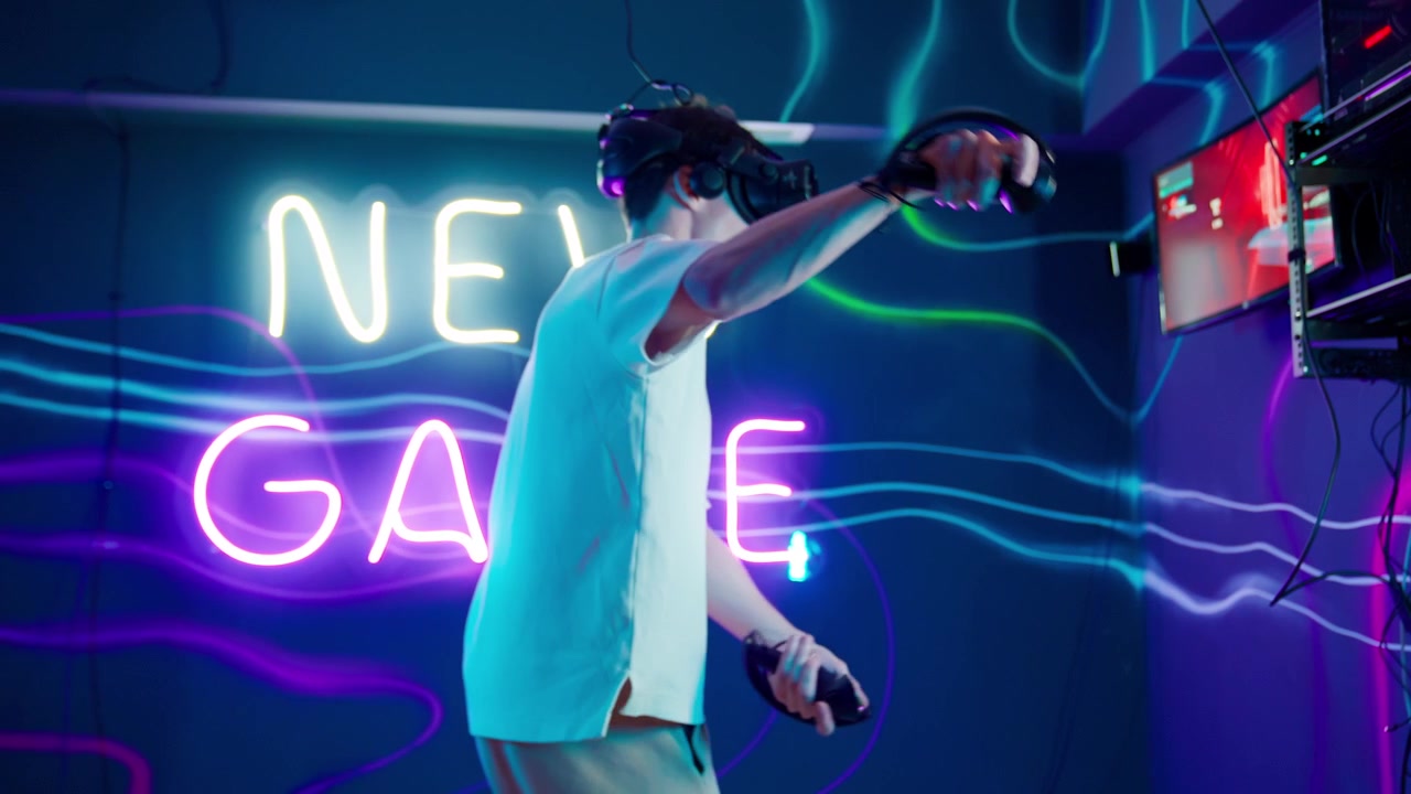 Giovane uomo che gioca a un gioco di realtà virtuale in una stanza illuminata al neon