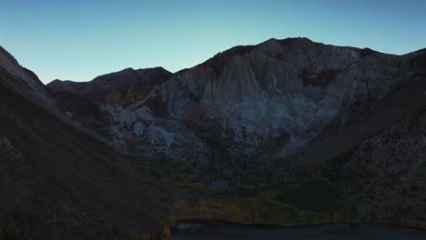 convict lake canyon trail rugged mountainside layers mammoth lakes drone aerial california autumn fall evening sunset shaded valley peaks clear skies yellow birch aspen trees forward motion