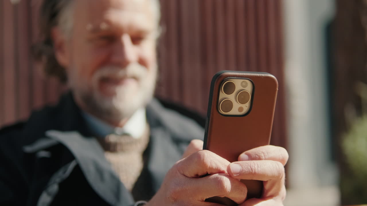 Smiling Senior Man Using Smartphone Outdoors