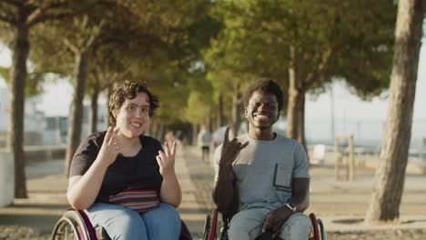 happy couple using wheelchairs showing positive gestures