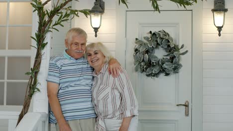 senior couple husband and wife embracing, showing love each to other in porch at home. mature family