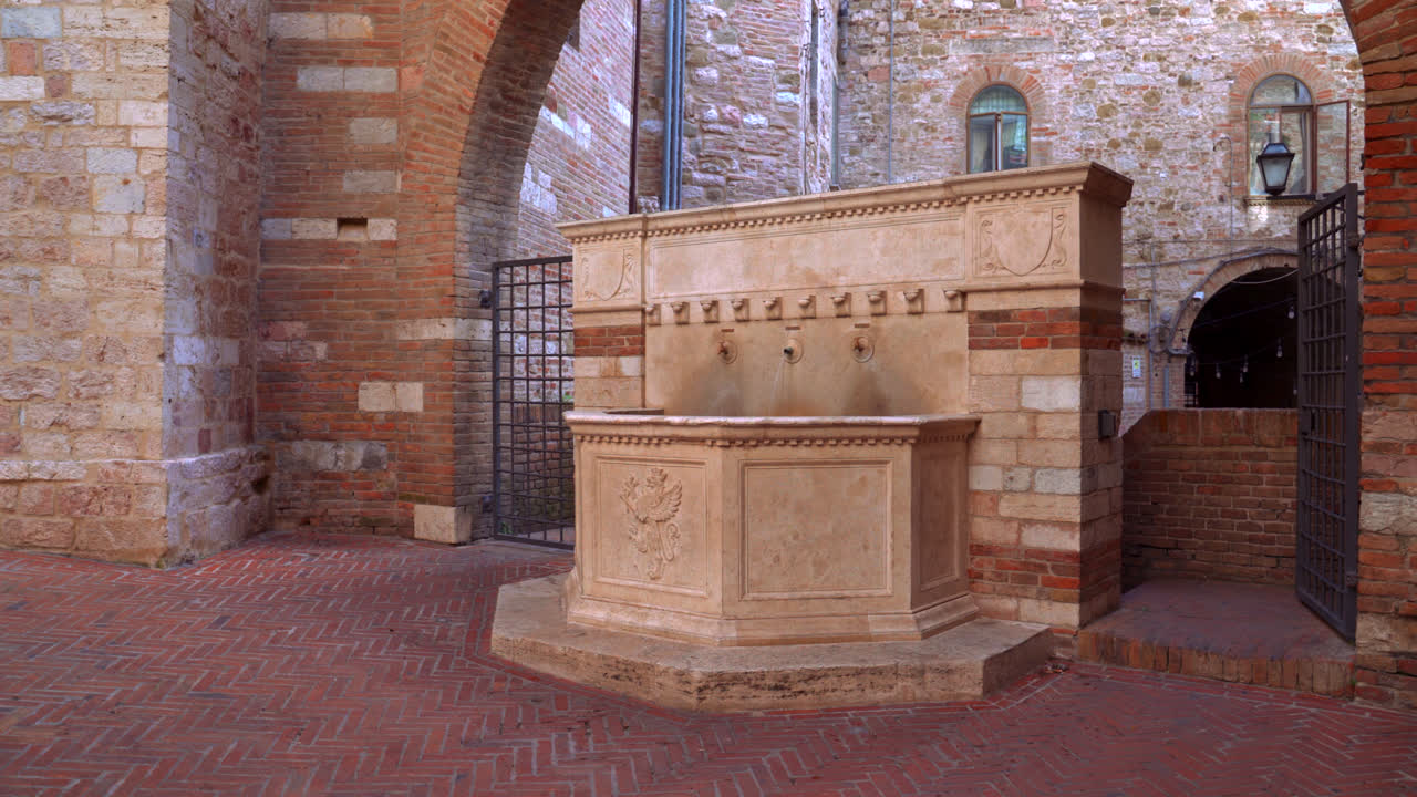 Ancient marble fountain standing in historic square surrounded by stone walls in Perugia