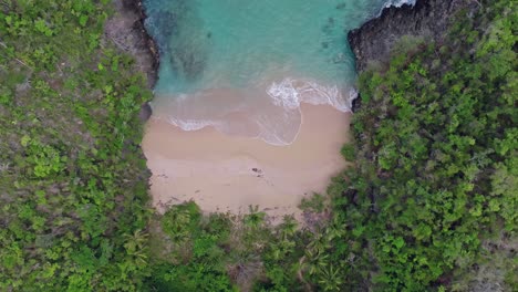 Top-view-of-waves-crashing-towards-the-shore-of-Playa-Onda-Samana-In-Dominican-Republic---drone-shot