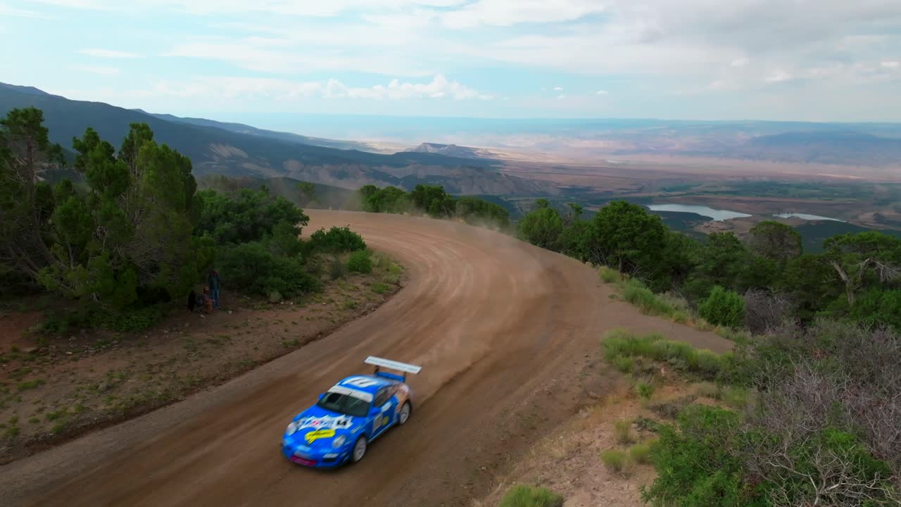 Corrida de rali de subida de montanha Lands End, piloto Jeff Swart, Grand Mesa, Grand Junction, Colorado. Estático, ensolarado, nuvens cinzentas, céu azul, Porsche azul, bandeira, estrada de terra, carro, velocidade, derrapagem, curva, alta velocidade, verificação, linha de chegada.