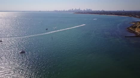 Reverse-drone-footage-with-boats-and-yachts-on-Port-Philip-Bay-with-Melbourne-city-skyline