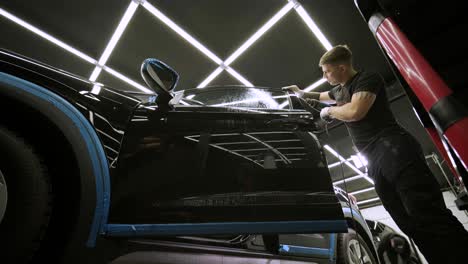 man covering car with vinyl polyurethane tape. films for the car. sticker protective film on the car