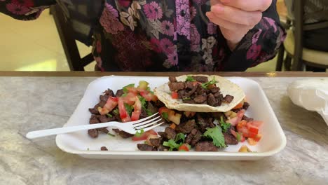 mujer mayor haciendo un taco de carne