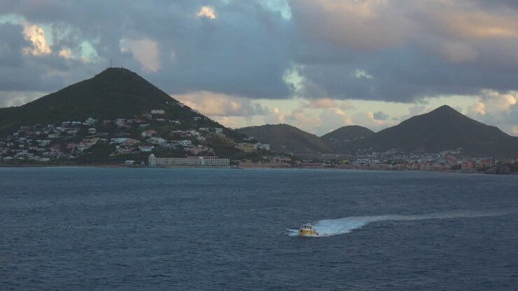 View of the pilot boat approaching the camera with Sint Maarten's Philipsburg in the background recorded from a passing cruise ship's balcony