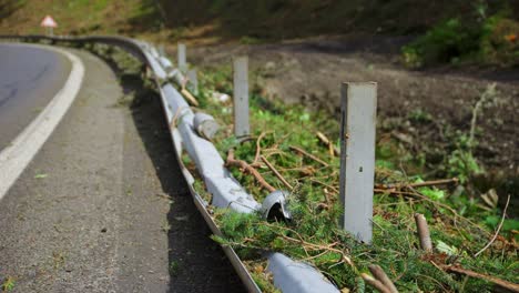 Guardrail-ripped-off-of-metal-support-beams-on-side-of-road-from-mudslide-that-tore-trees-off-hill