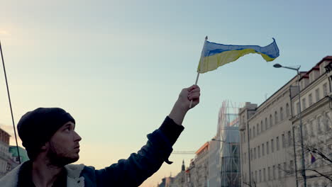 Mann-Schwenkt-Ukrainische-Flagge-Aus-Protest-Gegen-Krieg,-Prag,-Zeitlupe