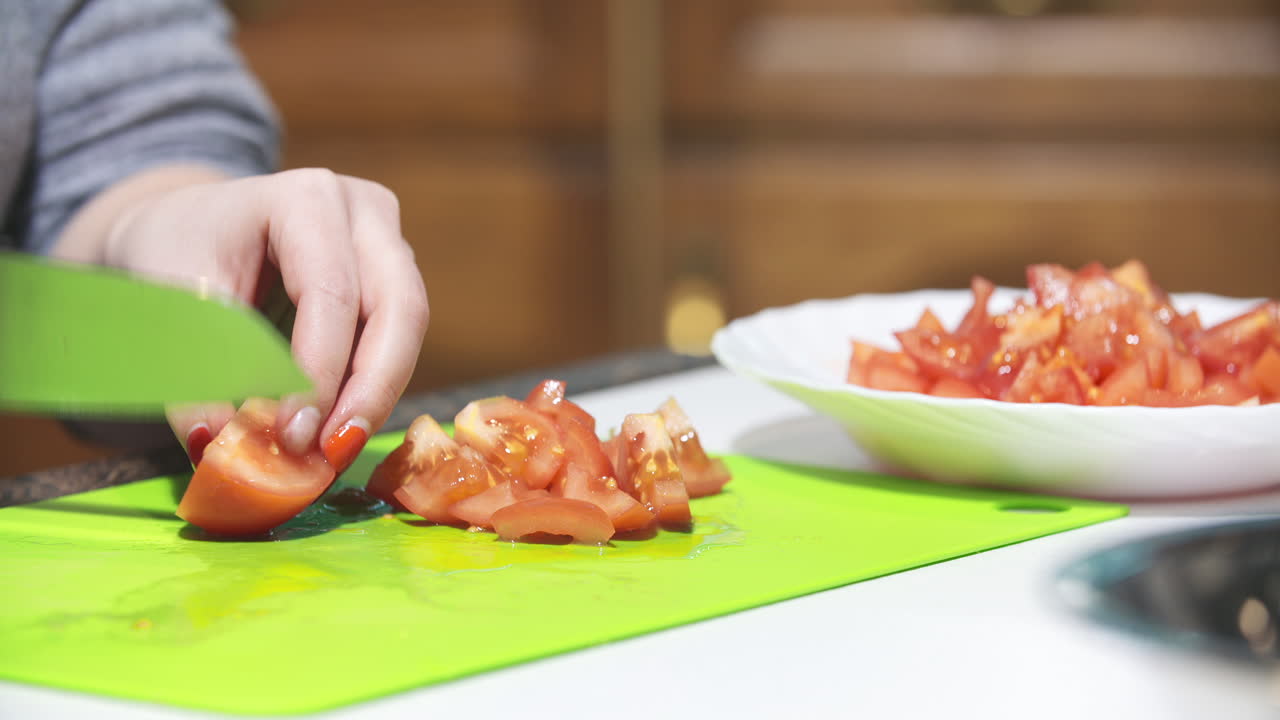 Woman Slicing Tomatoes onto a Plate