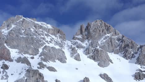 hermosa toma de avión no tripulado de la cordillera italiana nevada durante el tiempo soleado con cielo azul
