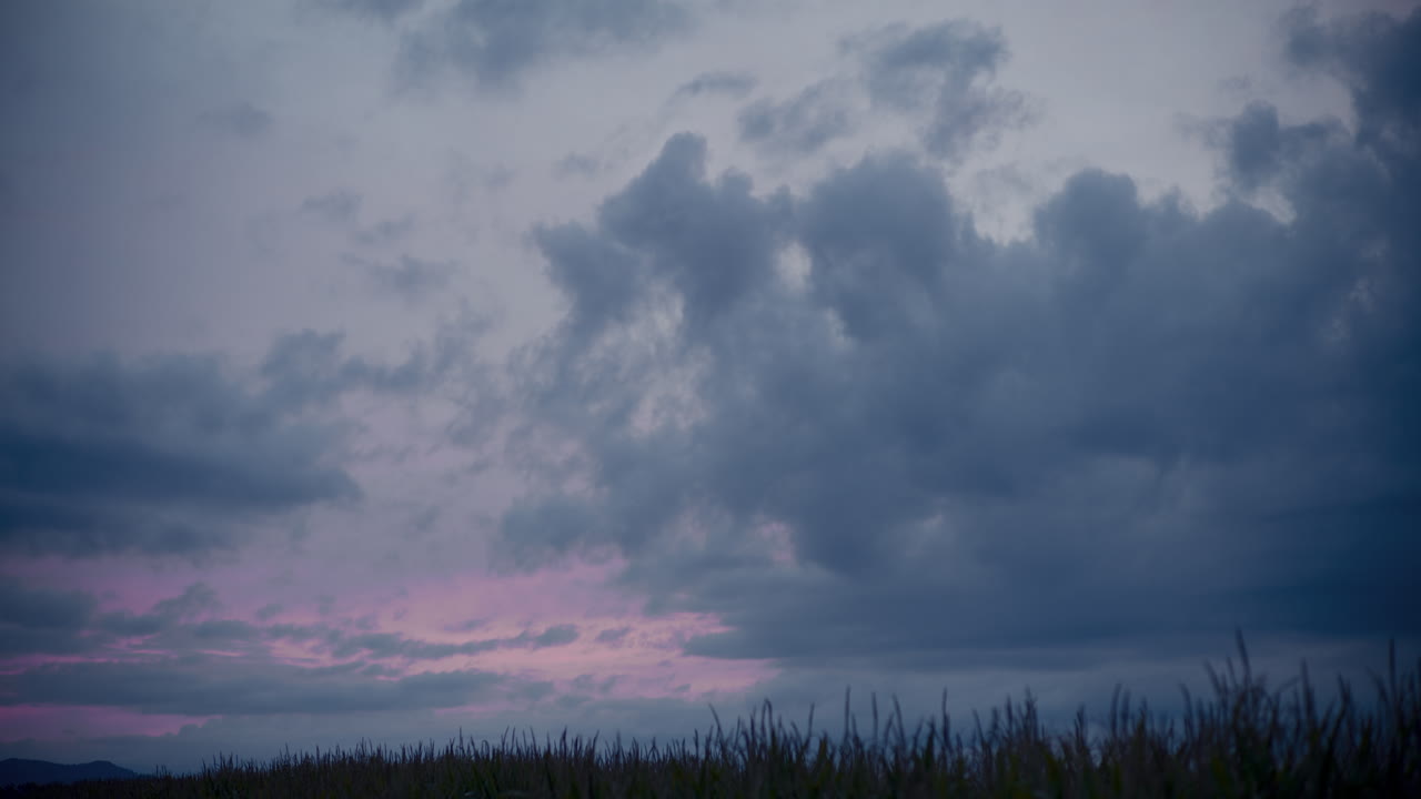 아름다운 구름이 풀 ⁇ 에서 잔디를 움직이고 있습니다.