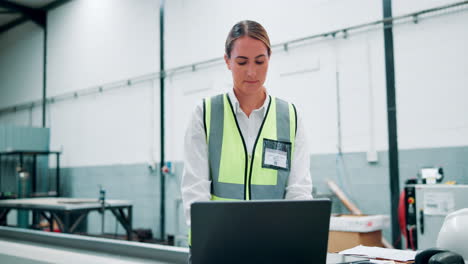 trabajadora de una fábrica que usa una computadora portátil