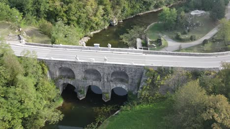 an aerial view over road and stone arched bridge in tounj, croatia in late summer