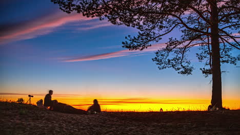 timalpse of campfire gathering under a vibrant evening sky