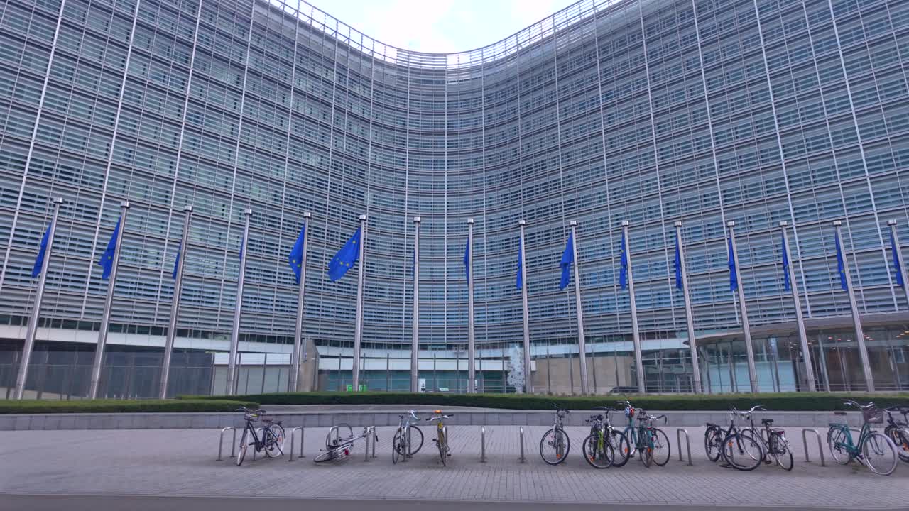 Bikes near Berlaymont building with EU flags and curved modern facade