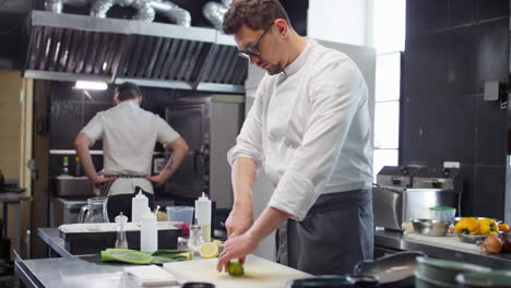 chef cutting leeks in restaurant kitchen