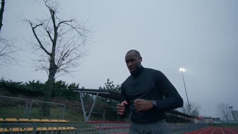 man running on a track in cloudy weather