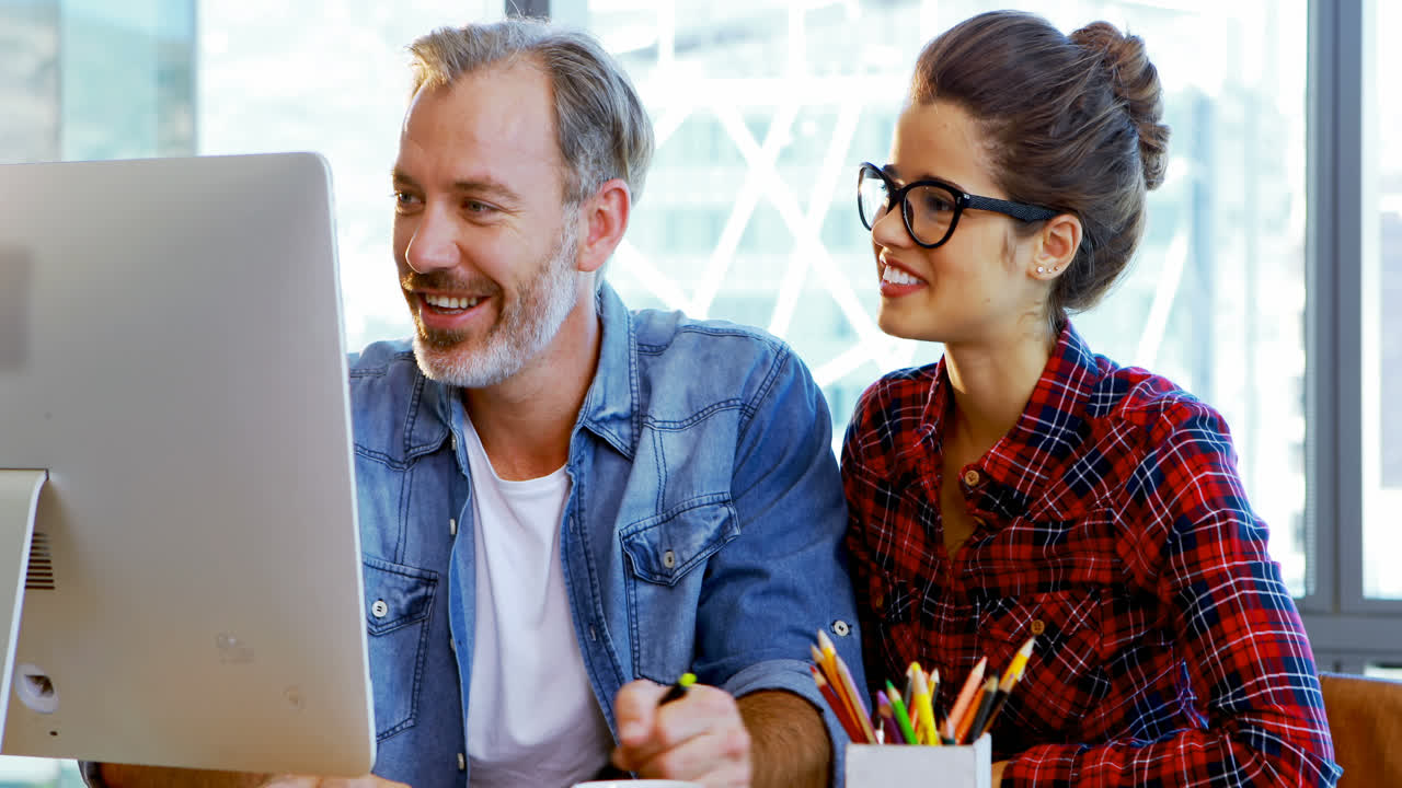 diseñadores gráficos masculinos y femeninos trabajando juntos en el escritorio