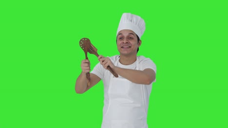 feliz chef profesional indio bailando y disfrutando de la pantalla verde