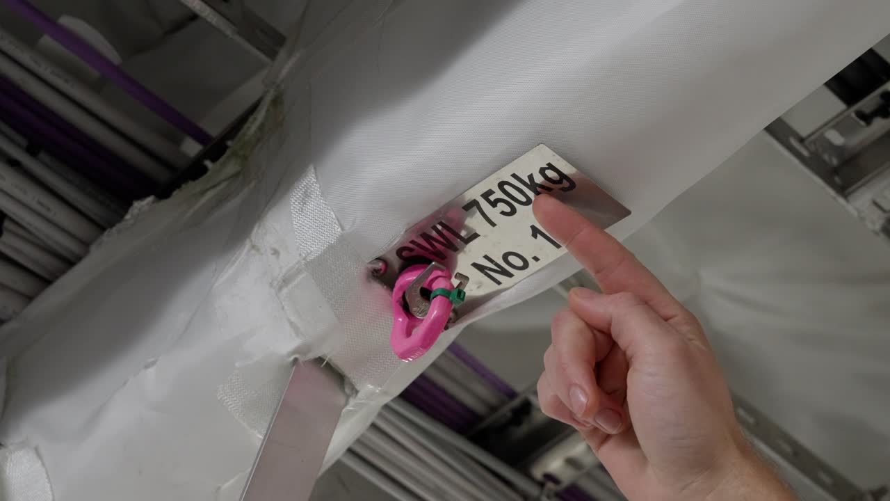 capitán inspeccionando el punto de elevación del barco en el techo, marcas de señalización swl 750 kg