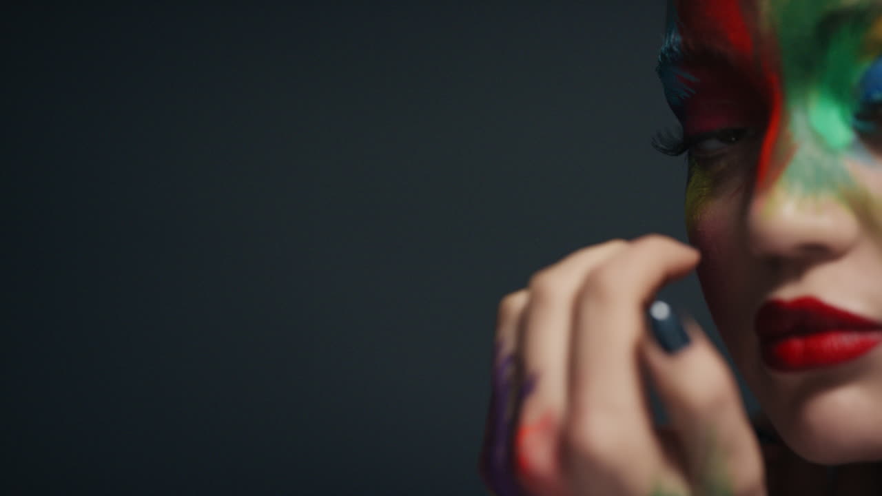 retrato de cerca mujer atractiva con cara pintada de colores exótico arte corporal multicolor sensual mujer que disfruta de la expresión creativa