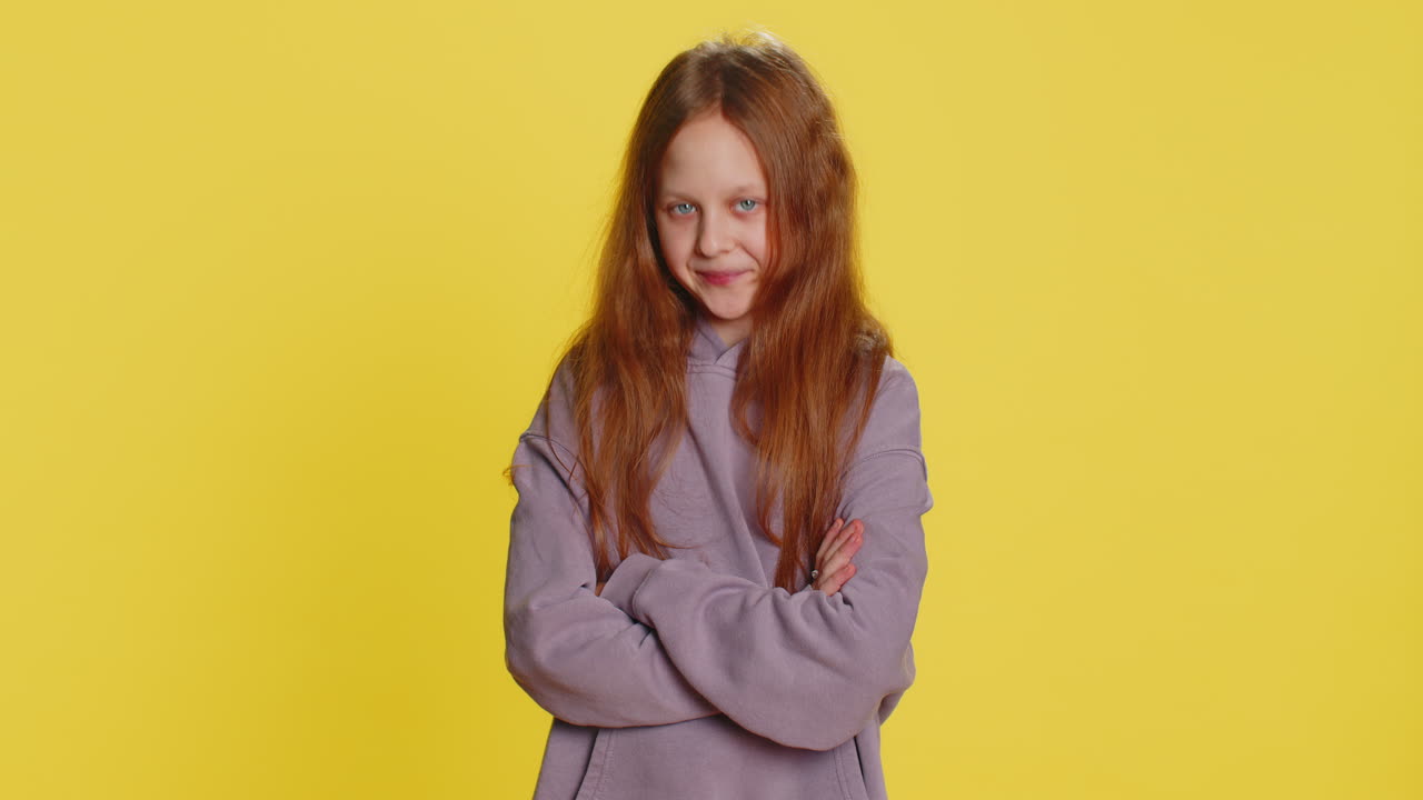 Bambina in età scolare che indica i suoi occhi e la telecamera, gesto di "ti sto osservando", che spia qualcuno