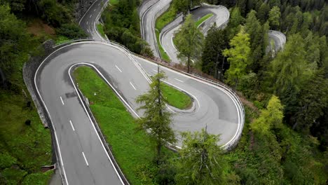 aerial flyover over the turns of maloja pass in engadin, switzerland with a pan up revealing the curves of the road