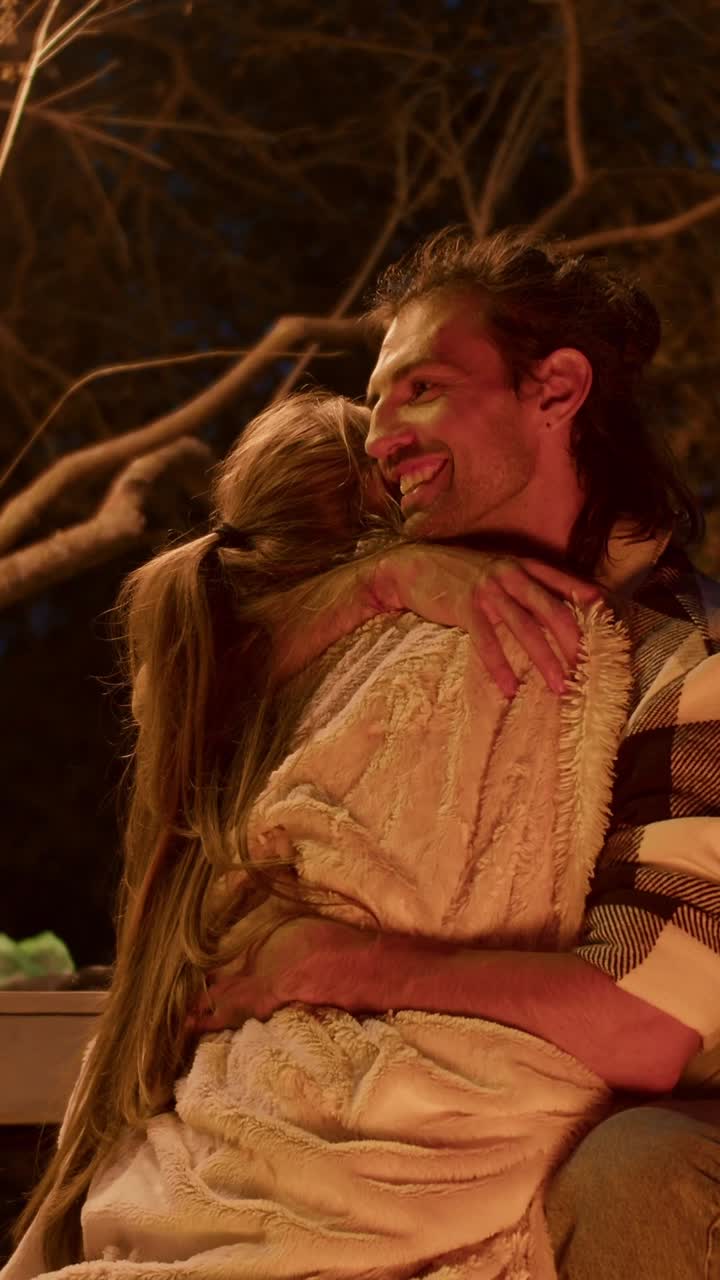 Couple Hugging by a Campfire