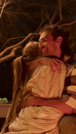 couple hugging by a campfire