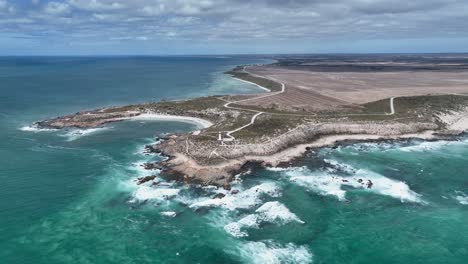 Drone-shot-orbiting-Corny-Point-lighthouse-near-the-rocky-shores-of-Corny-Point-and-Horse-Shoe-Bay