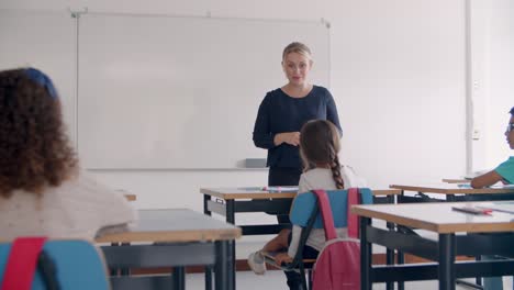 friendly female school teacher speaking at whiteboard