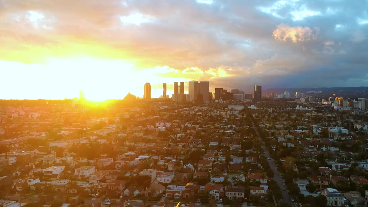 Impressionante tomada aérea em direção a um pôr do sol colorido ao longe