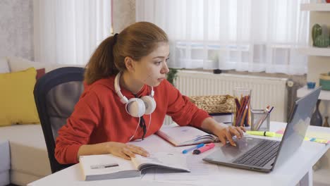 young student doing homework, researching with laptop.