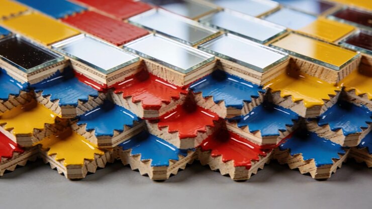 Pulling focus camera showing stacked tiles with mirrors and edges on studio table, revealing layers