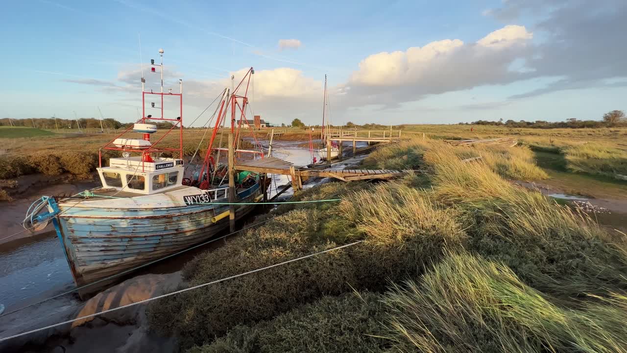 barco, velero atracado en el estuario con la luz del sol dorada por la noche
